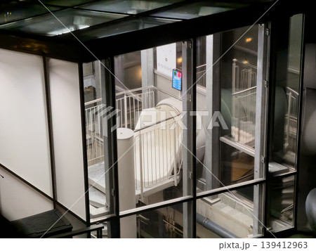 Futuristic white capsule transport system inside modern architectural building with sleek glass panels, symbolizing innovation and urban movement Futuristic white capsule transport system inside modern architectural building with sleek glass panels, symbolizing innovation and urban movement 139412963