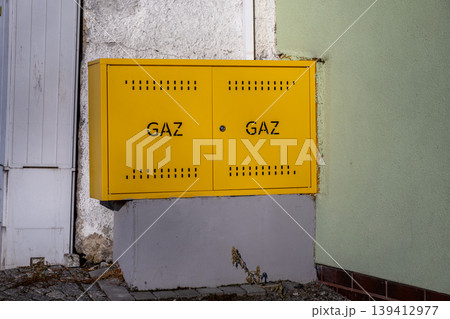Bright yellow gas meter box marked GAZ, a crucial component of essential energy infrastructure for modern residential and commercial buildings 139412977