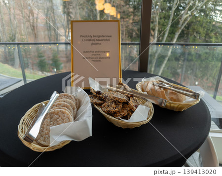 Buffet table with Gluten-free and low-gluten products sign, presenting healthy snack options and sliced bread for guests with specific dietary needs Buffet table with Gluten-free and low-gluten products sign, presenting healthy snack options and sliced bread for guests with specific dietary needs 139413020