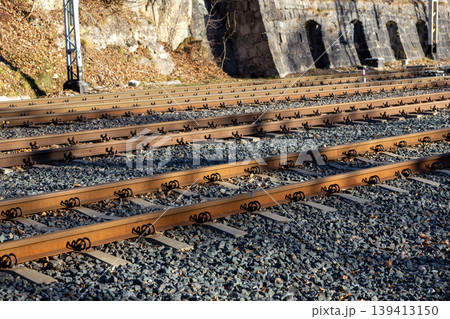 Parallel railway tracks extend through a scenic mountain passage with rocky embankments, symbolizing travel, journey, industrial connectivity, and infrastructure development within a natural landscape Parallel railway tracks extend through a scenic mountain passage with rocky embankments, symbolizing travel, journey, industrial connectivity, and infrastructure development within a natural landscape 139413150
