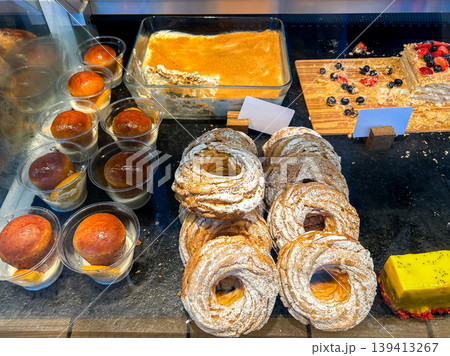 Assortment of sweet bakery and pastry displayed in showcase glass box in coffee shop. High quality photo. Assortment of sweet bakery and pastry displayed in showcase glass box in coffee shop. High quality photo. 139413267