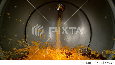 Gasoline jet pouring into metal fuel tank, inside view with dynamic splash and turbulence. Concept of refueling, fuel storage and energy supply, industrial environment. Gasoline jet pouring into metal fuel tank, inside view with dynamic splash and turbulence. Concept of refueling, fuel storage and energy supply, industrial environment. 139413603