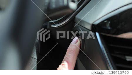 Elder woman presses engine start button in car. Close up woman hand, push start button in modern car. Elder woman presses engine start button in car. Close up woman hand, push start button in modern car. 139413790