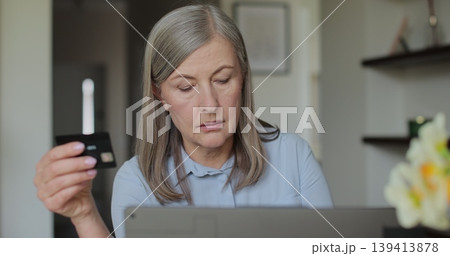 Old woman senior granny with laptop and bank credit card paying online shopping with computer buying internet payment. Online purchase. Old woman senior granny with laptop and bank credit card paying online shopping with computer buying internet payment. Online purchase. 139413878