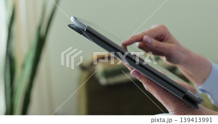 Close up. Senior woman using TabletPC on sofa in living room. Concept of retirement, free time, relax. 139413991
