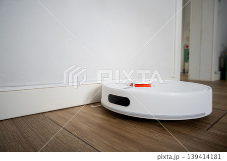 Robot vacuum cleaner cleaning wooden floor in modern living room Robot vacuum cleaner cleaning wooden floor in modern living room 139414181