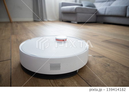 Robot vacuum cleaner cleaning wooden floor in modern living room Robot vacuum cleaner cleaning wooden floor in modern living room 139414182