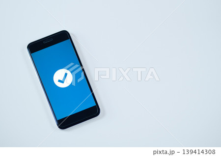 ブルーのチェックマークが表示されたスマートフォンの完了画面 ブルーのチェックマークが表示されたスマートフォンの完了画面 139414308