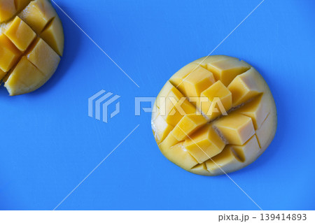 Fresh sliced mango cubes on blue background with copy space Fresh sliced mango cubes on blue background with copy space 139414893