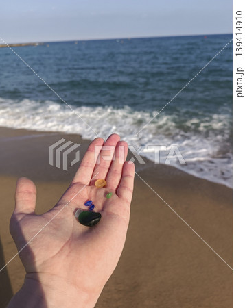 Hand holding colorful sea glass on sunny beach 139414910