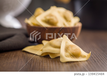 Fresh Uncooked Ravioli Pasta On Wooden Table With Bowl, Homemade Italian Dumplings Fresh Uncooked Ravioli Pasta On Wooden Table With Bowl, Homemade Italian Dumplings 139415484