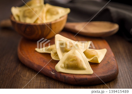 Triangular Ravioli Pasta On Wooden Board With Spoon Rustic Uncooked Italian Dough 139415489