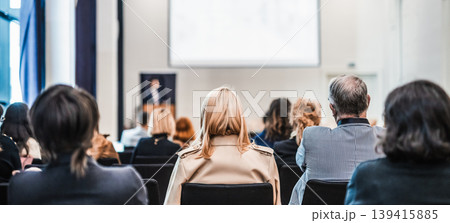 Speaker giving a talk in conference hall at business event. Rear view of unrecognizable people in audience at the conference hall. Business and entrepreneurship concept 139415885