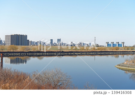 水面に映る都市のビル群 澄み渡る青空と芝川水門が調和するリバーサイドの穏やかな風景 水面に映る都市のビル群 澄み渡る青空と芝川水門が調和するリバーサイドの穏やかな風景 139416308