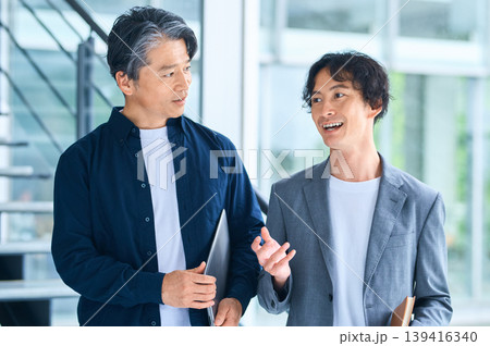笑顔で会話する30代と50代の日本人男性ビジネスマン 笑顔で会話する30代と50代の日本人男性ビジネスマン 139416340
