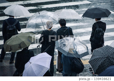 梅雨イメージ、雨の日に傘を差して信号待ちをする人々 139416621