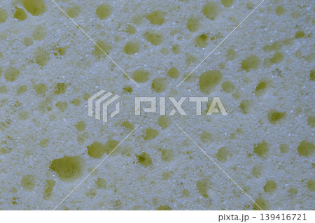 Macro photography of a light foam sponge surface showing a clean network of polymer fibers and open pores. The soft shadows create a deep 3D organic pattern 139416721