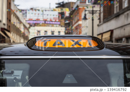 Close up of a yellow taxi sign on a black cab in the city 139416792