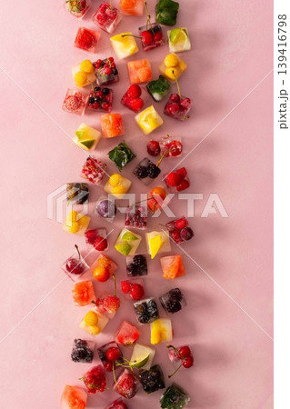 Ice cubes with frozen berries and fruits and mint on a pink background Ice cubes with frozen berries and fruits and mint on a pink background 139416798