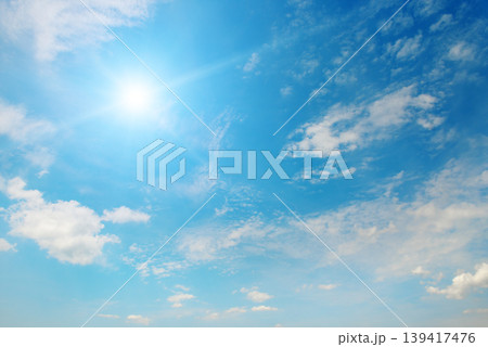 Bright Sun Shining in the Clear Blue Sky with Soft White Clouds 139417476