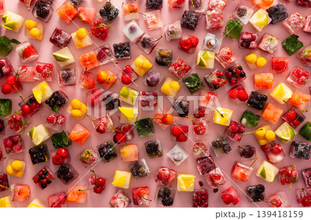 Ice cubes with frozen berries and fruits and mint on a pink background Ice cubes with frozen berries and fruits and mint on a pink background 139418159