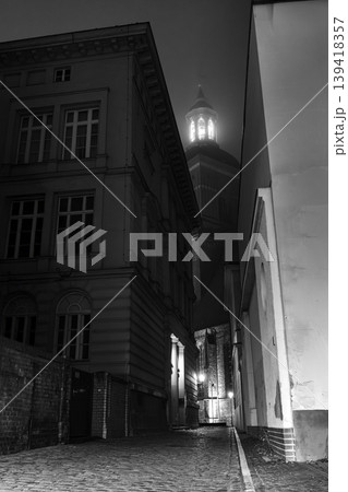Illuminated Tower Between Narrow Streets at Night in Black and White 139418357