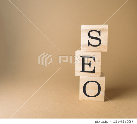 Stacked wooden blocks displaying letters SEO on a neutral background with soft lighting effects 139418557