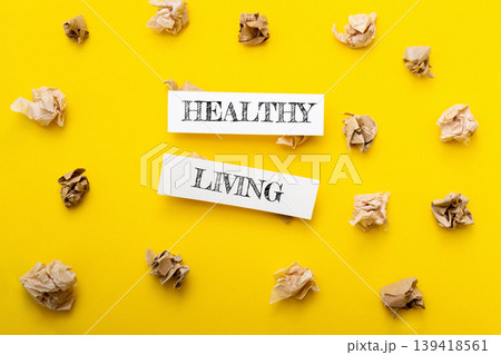Healthy living concept with crumpled paper surrounding bold text on vibrant yellow background, symbolizing wellness and lifestyle choices for improved health and vitality Healthy living concept with crumpled paper surrounding bold text on vibrant yellow background, symbolizing wellness and lifestyle choices for improved health and vitality 139418561