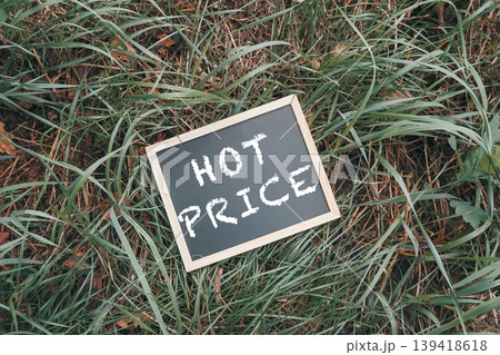 Chalkboard Sign Displaying Hot Price on Grass Chalkboard Sign Displaying Hot Price on Grass 139418618