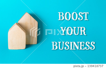 Two wooden houses are on a blue background with the words boost your business" Two wooden houses are on a blue background with the words boost your business" 139418737