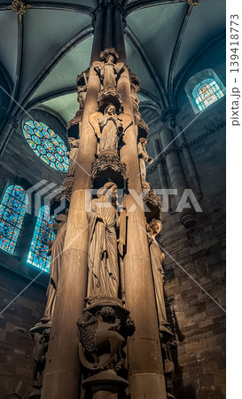 Intricate stone column featuring detailed sculptures in a historic cathedral with stained glass Intricate stone column featuring detailed sculptures in a historic cathedral with stained glass 139418773