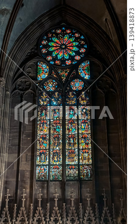 Stained glass window featuring intricate designs and vibrant colors, illuminating the interior of a historic cathedral with gothic architecture and spiritual ambiance Stained glass window featuring intricate designs and vibrant colors, illuminating the interior of a historic cathedral with gothic architecture and spiritual ambiance 139418873