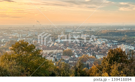 Scenic view of a vibrant cityscape during sunset, showcasing a blend of urban architecture and lush greenery, creating a serene atmosphere with warm colors Scenic view of a vibrant cityscape during sunset, showcasing a blend of urban architecture and lush greenery, creating a serene atmosphere with warm colors 139418894