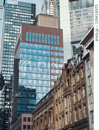 Modern skyscrapers and historic buildings juxtaposed in urban cityscape with reflective glass 139418972