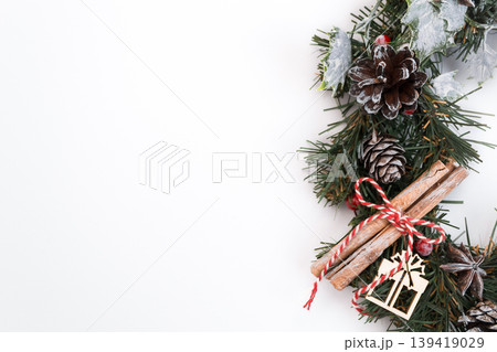 Festive Christmas wreath with pinecones, cinnamon sticks, and decorative elements on white background Festive Christmas wreath with pinecones, cinnamon sticks, and decorative elements on white background 139419029