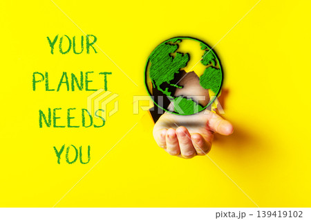 Hand holding a globe with the words Your planet needs you written below it Hand holding a globe with the words Your planet needs you written below it 139419102