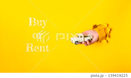 Hand holding a toy truck emerging from a yellow background with text suggesting buy or rent options Hand holding a toy truck emerging from a yellow background with text suggesting buy or rent options 139419225