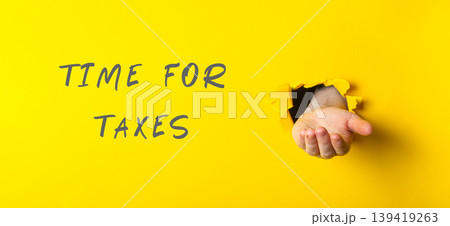 Hand emerging from yellow background with text indicating tax season and financial awareness Hand emerging from yellow background with text indicating tax season and financial awareness 139419263
