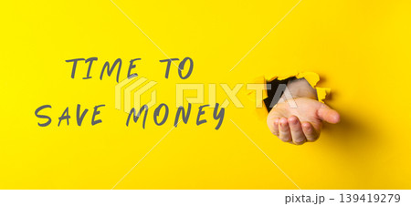 Hand emerging from yellow wall with message about saving money and financial awareness 139419279