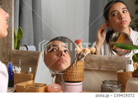 Teen Girl Applying Makeup in Front of Mirror 139419372