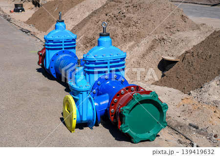 Large industrial pipeline valves on roadside construction site with sand piles and utility works Large industrial pipeline valves on roadside construction site with sand piles and utility works 139419632