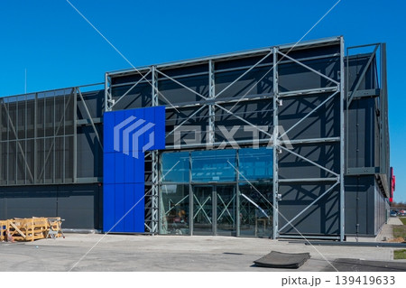 Modern industrial building facade with glass entrance steel frame and construction equipment Modern industrial building facade with glass entrance steel frame and construction equipment 139419633