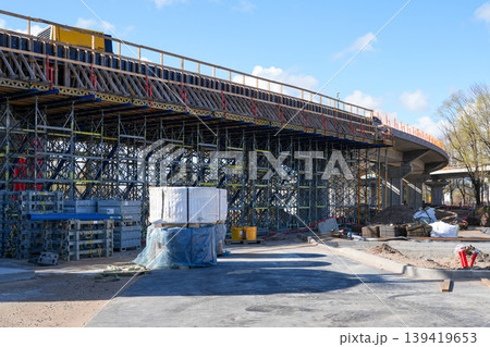 Elevated road bridge under construction with dense scaffolding and formwork on a sunny day scene Elevated road bridge under construction with dense scaffolding and formwork on a sunny day scene 139419653