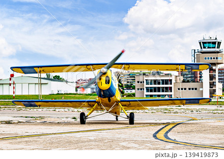 A yellow single-engine ultralight aircraft on the airfield runway. A yellow single-engine ultralight aircraft on the airfield runway. 139419873