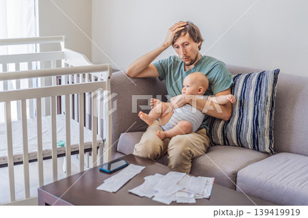 Father sitting on sofa holding baby while calculating monthly expenses with receipts at home. Stressed dad managing budget and childcare. Financial stress, parenthood and real life concept Father sitting on sofa holding baby while calculating monthly expenses with receipts at home. Stressed dad managing budget and childcare. Financial stress, parenthood and real life concept 139419919