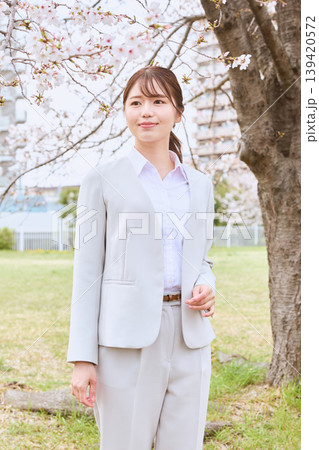 桜の下で微笑む白いスーツ姿の若い女性・春のビジネスポートレート・新生活イメージ 桜の下で微笑む白いスーツ姿の若い女性・春のビジネスポートレート・新生活イメージ 139420572
