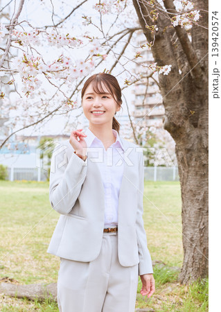 桜の木の下で微笑む白いスーツ姿の若い女性・春のポートレート・新生活イメージ 桜の木の下で微笑む白いスーツ姿の若い女性・春のポートレート・新生活イメージ 139420574