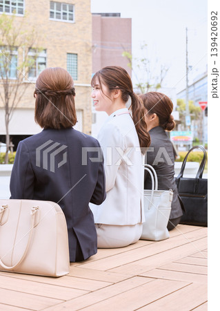 街中を並んで歩く二人の若い女性ビジネスパーソン・スーツ姿の就職活動中のリクルートスタイル 街中を並んで歩く二人の若い女性ビジネスパーソン・スーツ姿の就職活動中のリクルートスタイル 139420692