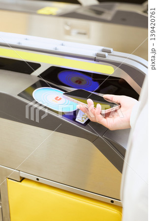 駅の自動改札機にスマートフォンをかざして通過する手元・モバイル交通系ICカード決済イメージ 駅の自動改札機にスマートフォンをかざして通過する手元・モバイル交通系ICカード決済イメージ 139420761