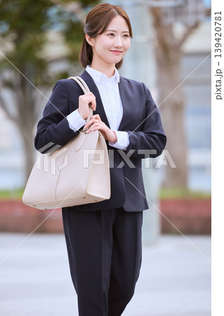 ビジネスバッグを持って歩く就職活動中のリクルートスーツ姿の若い女性・就活生の通勤イメージ ビジネスバッグを持って歩く就職活動中のリクルートスーツ姿の若い女性・就活生の通勤イメージ 139420781